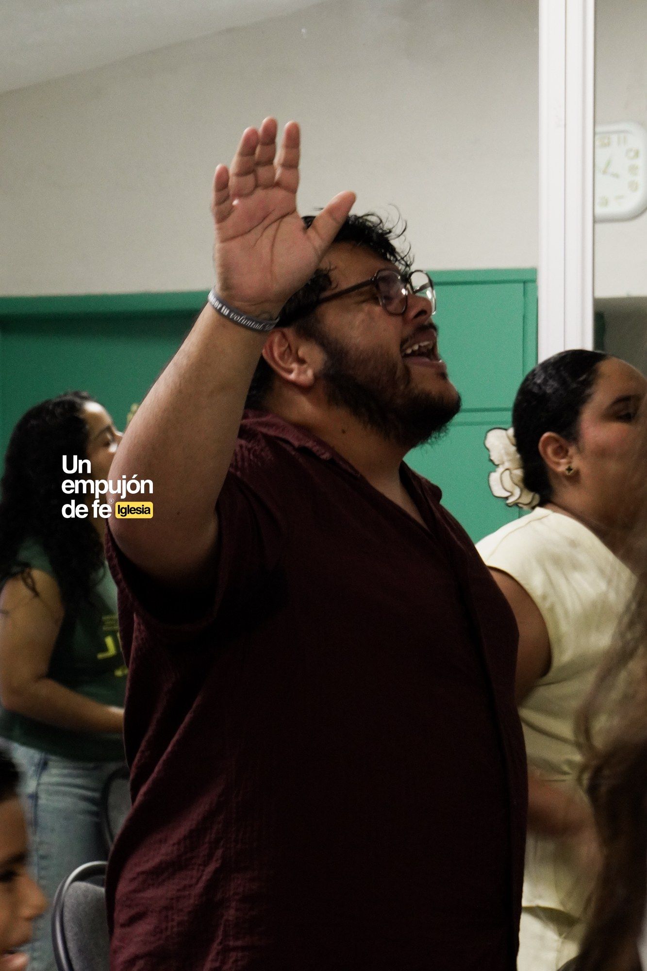 Una persona levanta la mano durante la adoración en el servicio dominical de Un Empujón de Fe, en Cancún