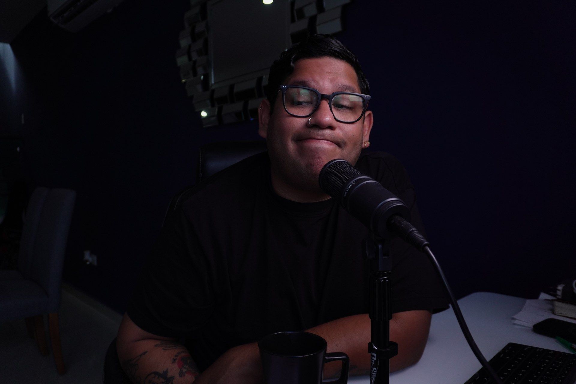 Chris Yáñez graba un episodio de Un Empujón de Fe frente al micrófono, en su estudio en Cancún